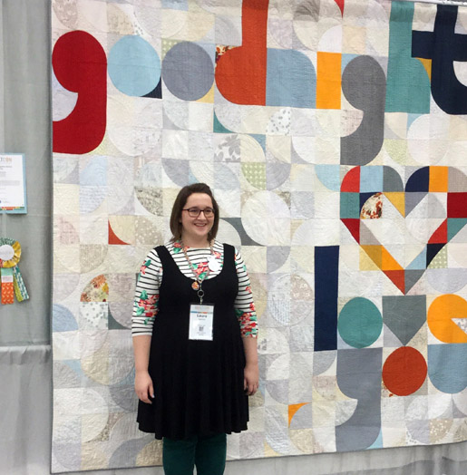 Laura Hartrich with her quilt, Quilt for Our Bed