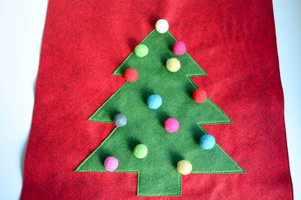 Christmas Tree Pillow Tutorial - Arrange the pom poms on the pillow front to your liking