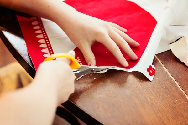 Little girl cutting out pattern on cloth