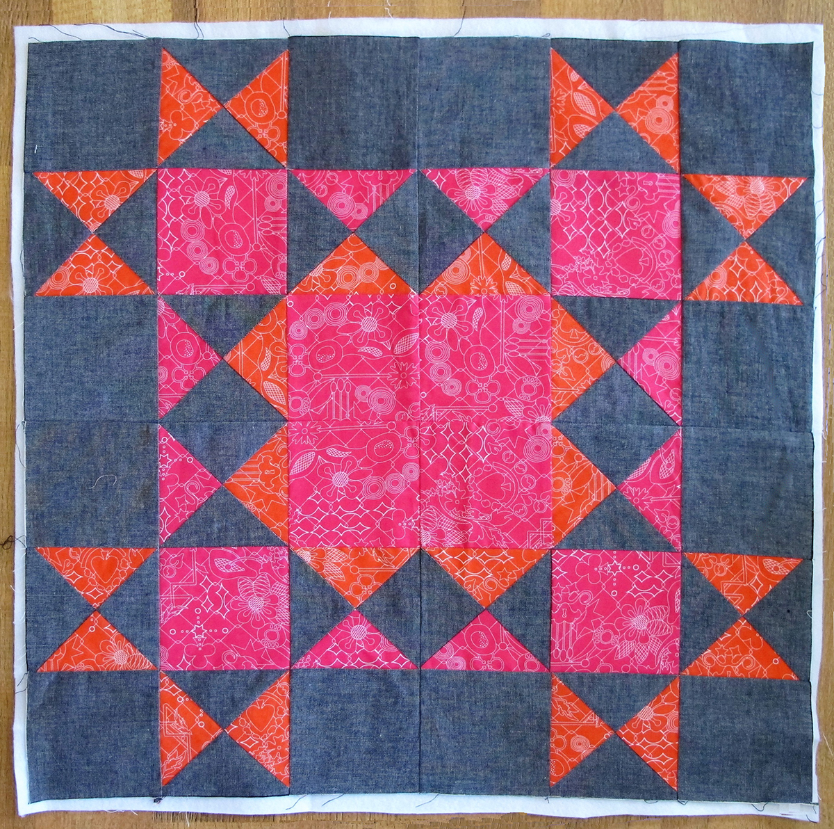 Seam the four blocks together with the pink corner square facing the center of the large 24 ½″ square