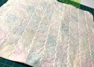 The backside of the patchwork quilt for 18 inch doll with stipple stitch
