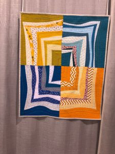 Machine quilting and hand stitches add tot he texture of this quilt by Olga Bocharova as seen at QuiltCon