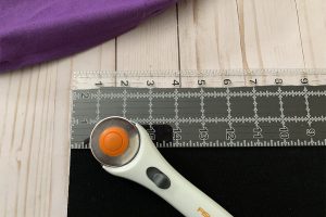 Image of black rib knit, a ruler, and rotary cutter.