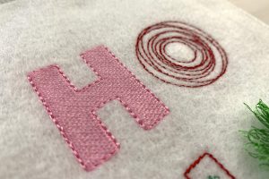 Close up of the first two letters, a pink H and a red O.