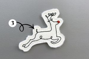 Callout showing the final color for the machine embroidered reindeer feltie design—white.