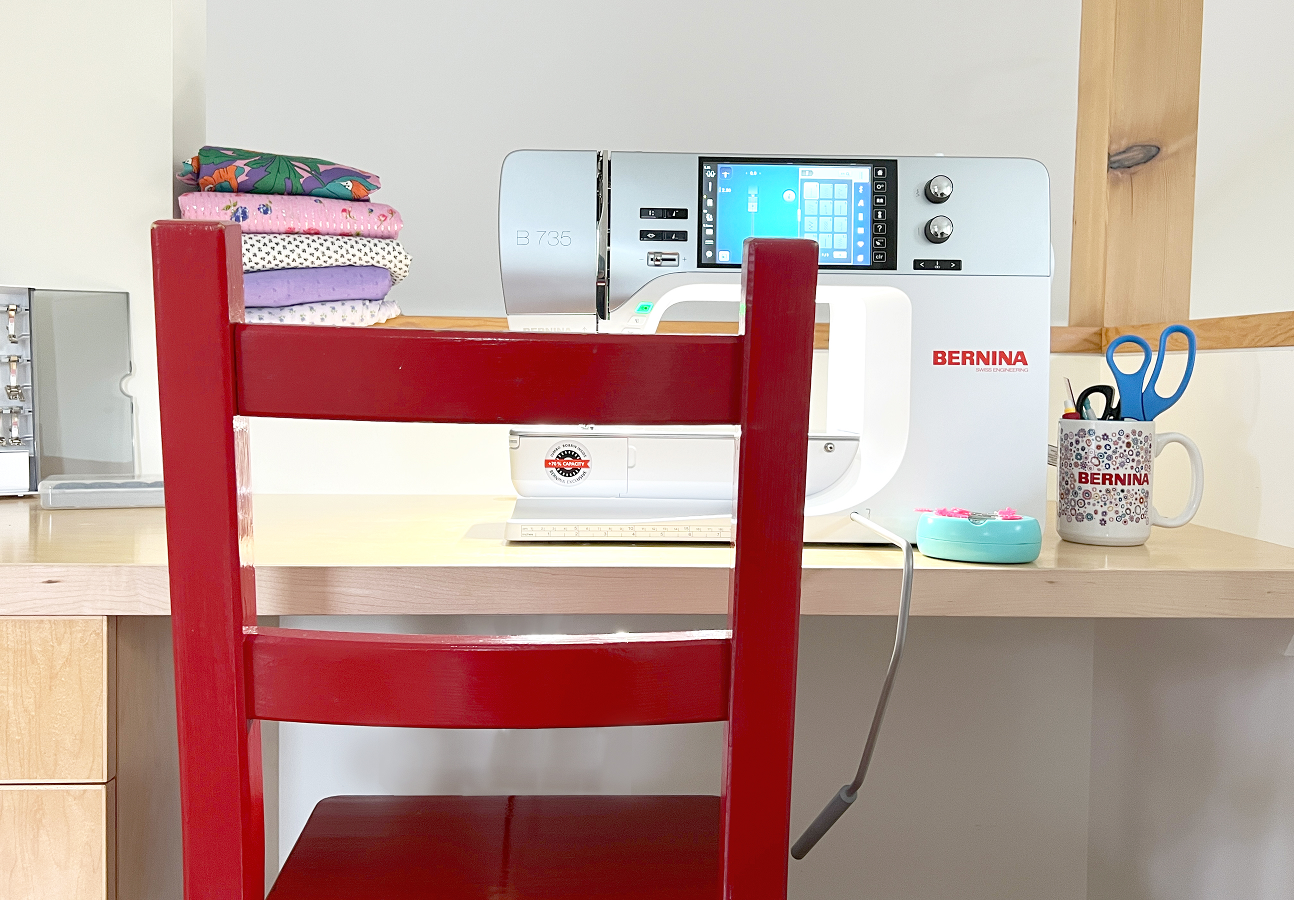 A red chair set up in front of a BERNINA sewing machine.