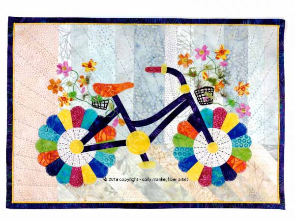 Mini Whimsical Bicycle showing fused raw edge appliqué finished with machine blanket stitch.