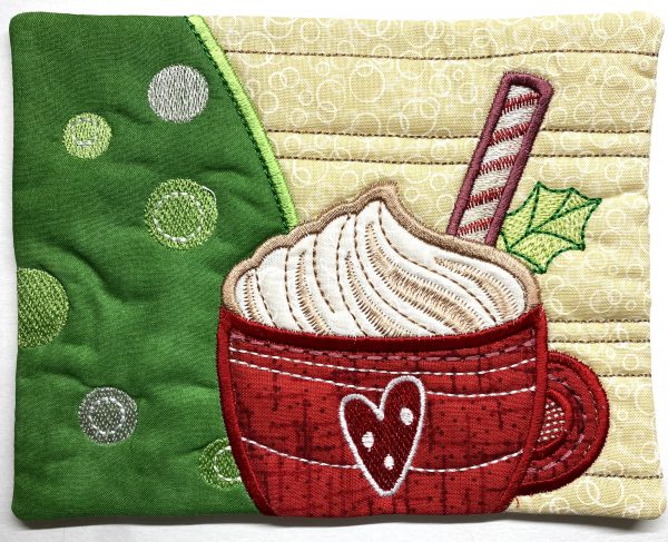 Completed Mug Rug featuring a cup of hot cocoa created with In The Hoop appliqué and embroidery.