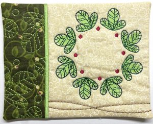 Completed Mug Rug featuring a cute green wreath created with In The Hoop appliqué and embroidery.