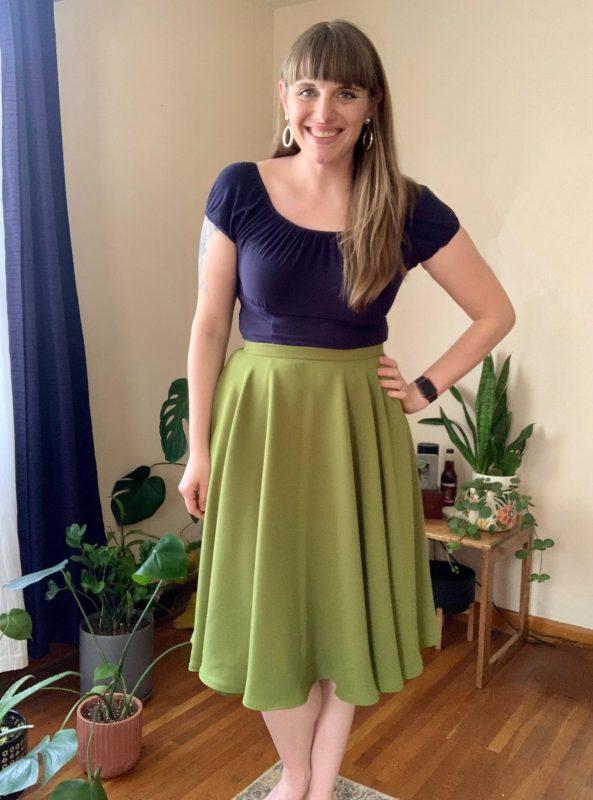 A white woman in a green circular skirt and blue top