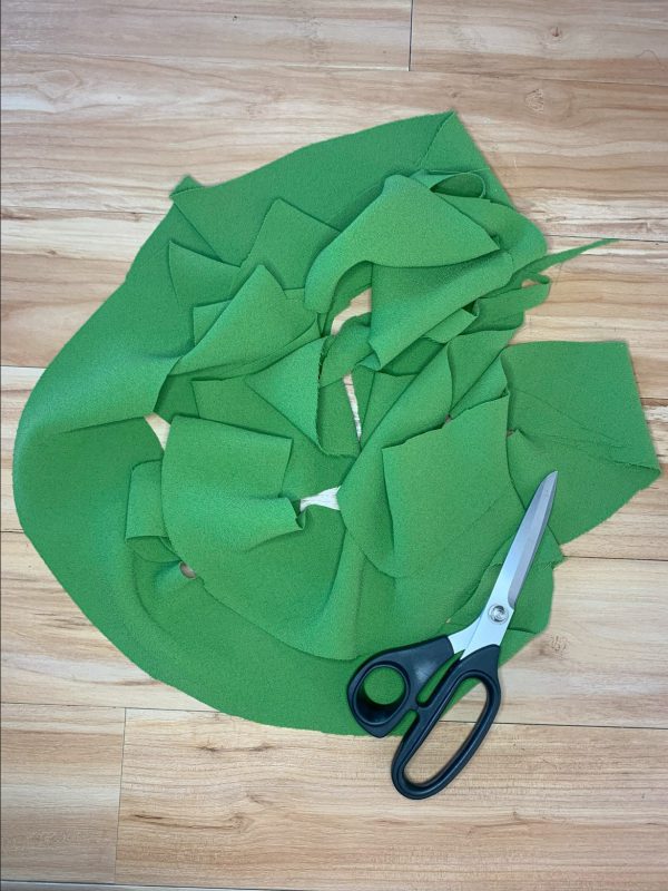 Green fabric trimmed skirt hem and scissors