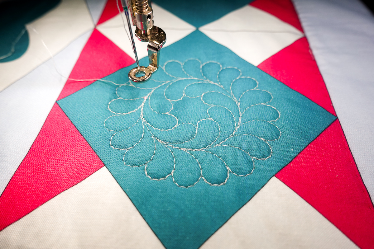 a quilted motif on the blue Diamond Block of the Jump for Joy quilt.