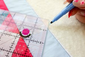 A closeup view of a blue pen marking the square around an omnigrip ruler.