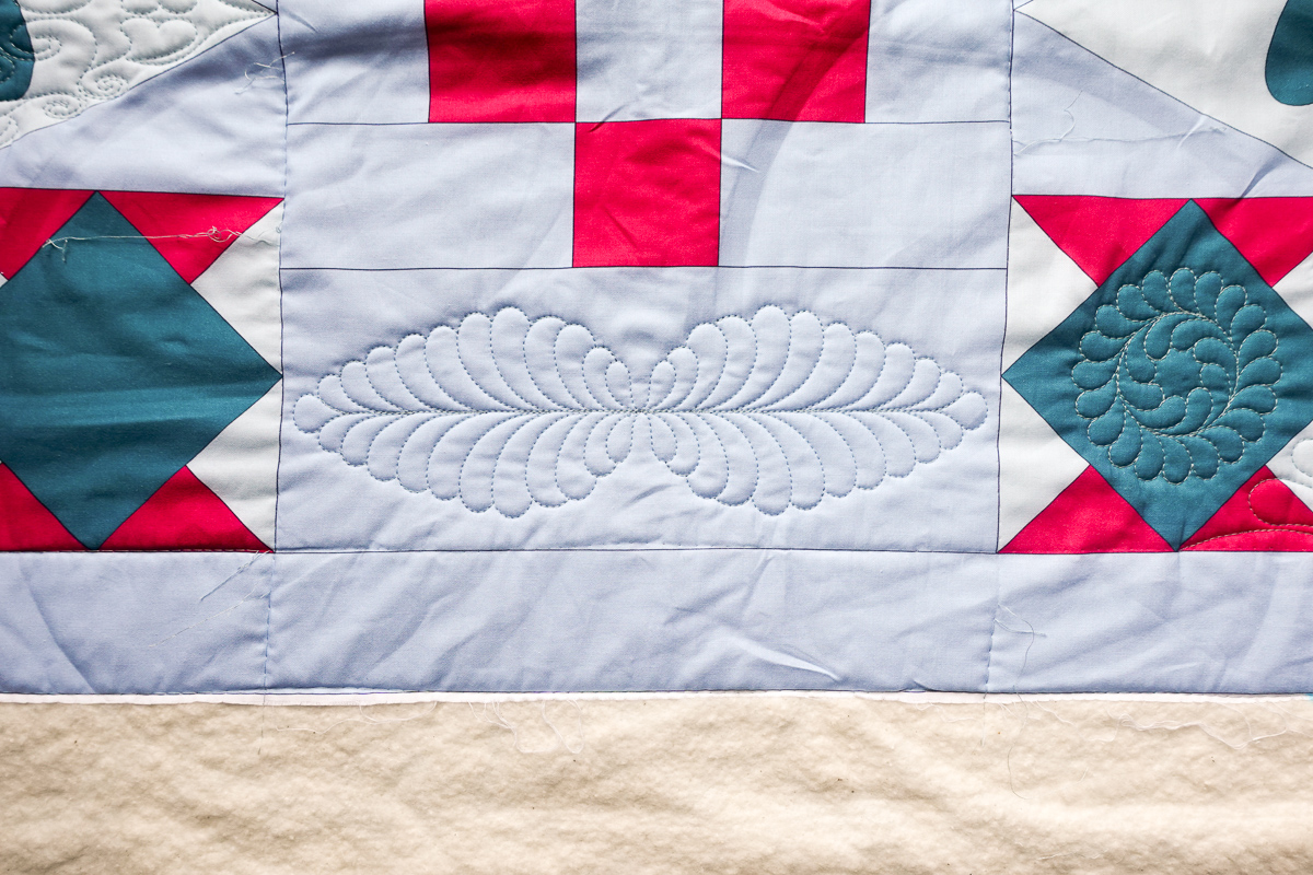 View of a quilted white panel between the Diamond Blogs of the Jump for Joy Quilt.