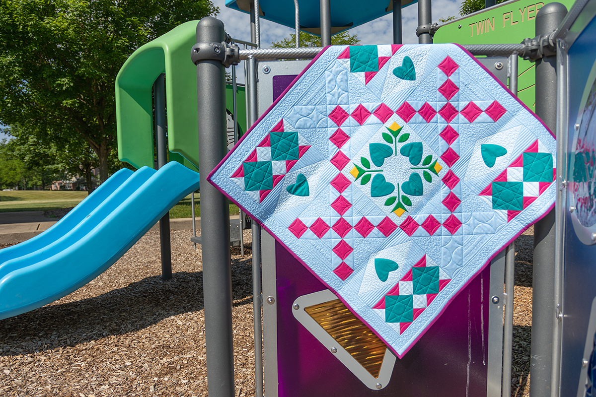 Jump For Joy Quilt displayed in a sunny playground.
