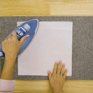 fuse stabilizer; an iron pressing Shape Flex onto a square of fabric