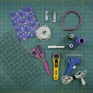 various sewing and serger supplies arranged on a green cutting mat