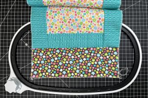 multi-color fabric laying over an embroidery hoop