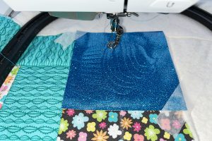 embroidery in progress on blue vinyl