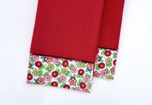 Overhead view of a flowered and red napkin that has been upcycled.