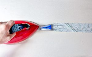 Red ironing bias with tape maker on white background