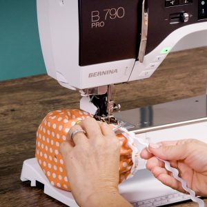 trimming the excess rickrack off of the sewn orange fabric bowl