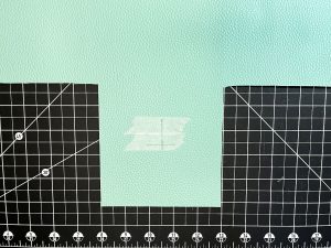 Vinyl right side up on black cutting mat with taped markers