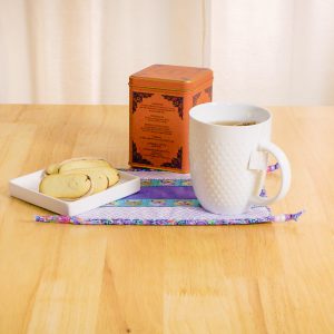 Cup of tea and snack sitting on a handsewn snack mat.