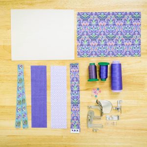 various fabrics, thread, tools, and accessories to sew a snack mat.