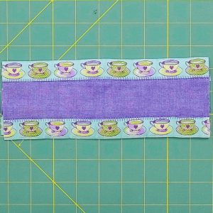 Finished overhead view of the center strip and ribbon borders flat on a cutting board.