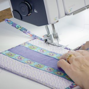 Front view of fabric being fed through the serger.