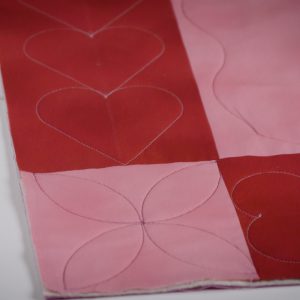 Overhead view of red and pink checkered quilt with orientation line