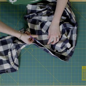 Scissors being used to cut around collar of shirt