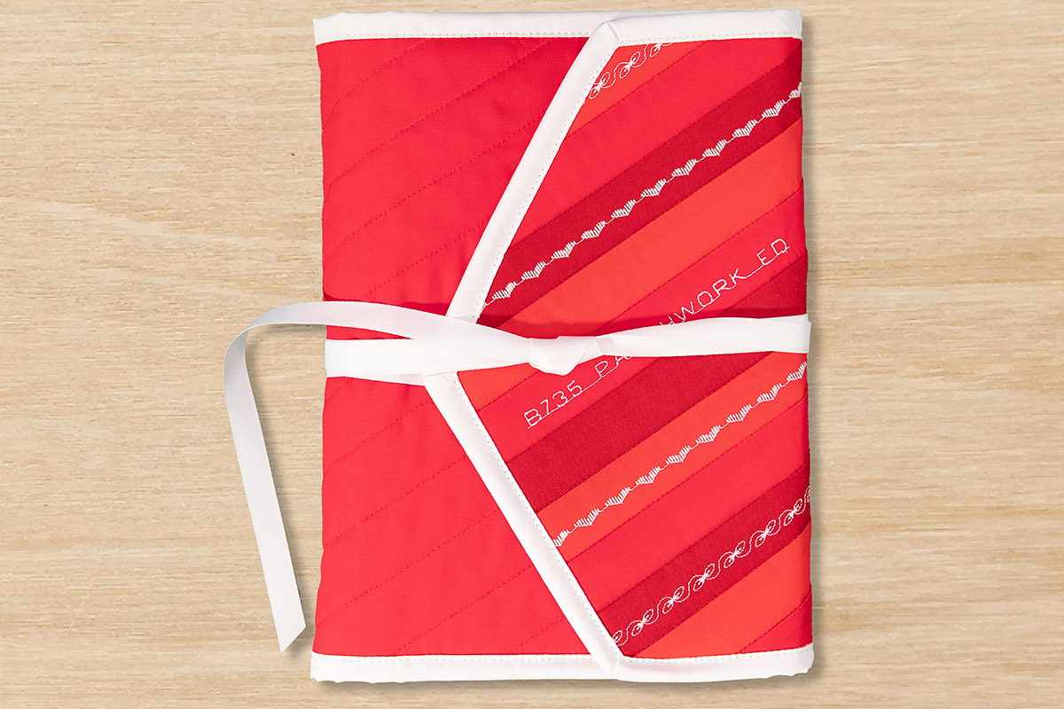 Red notebook wrap closed on a wood table