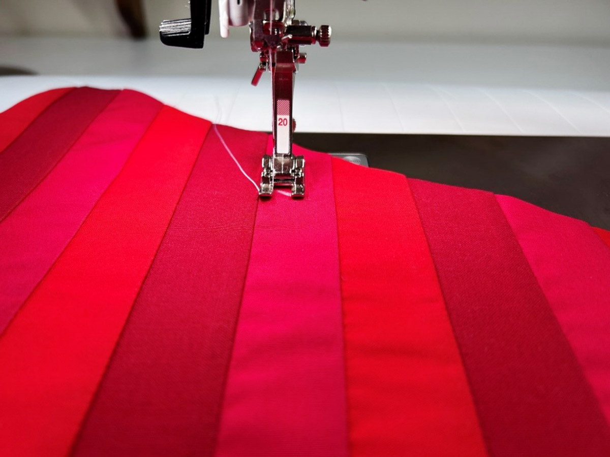 sewing along the seam of red fabric with foot #20