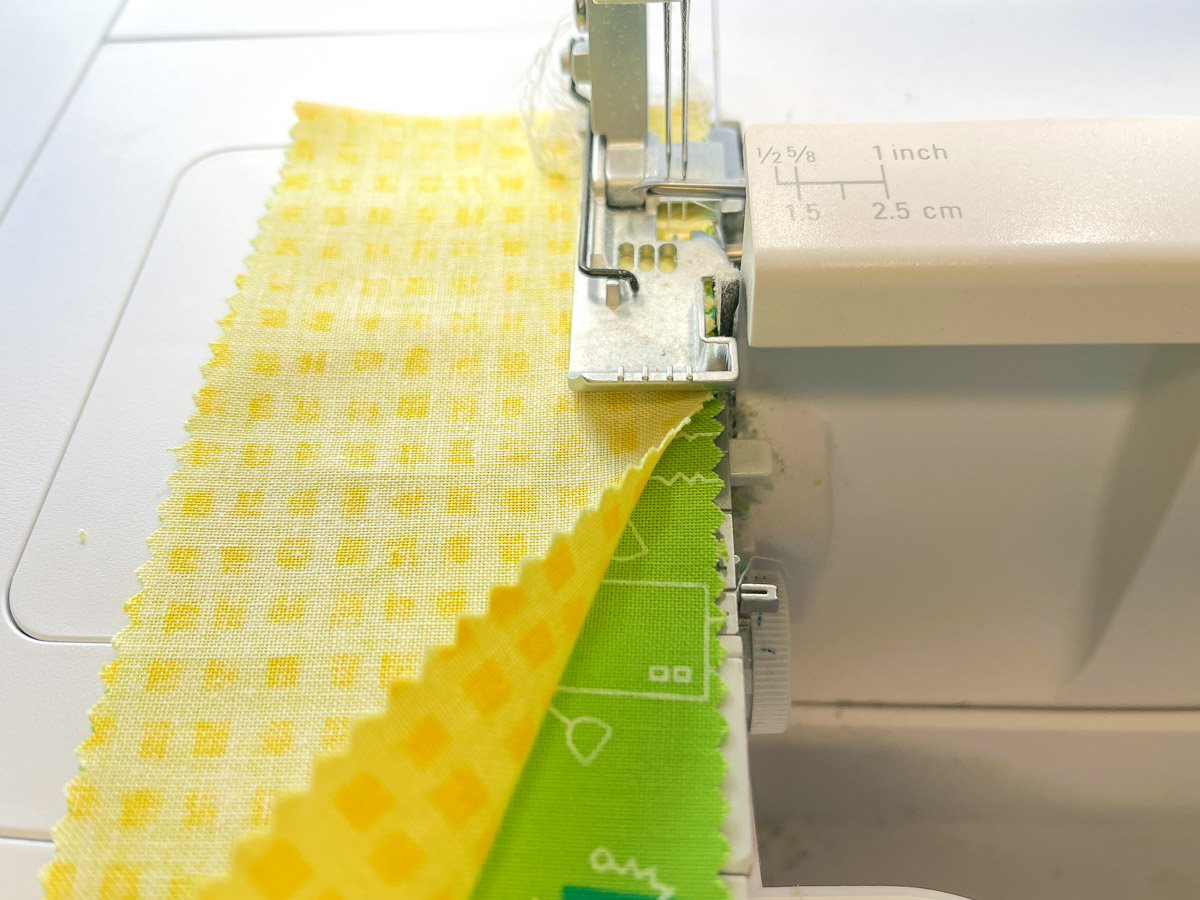 yellow fabric being serged to green fabric