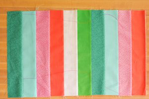 Blue, red, pink, and green striped fabric piece with stocking template marked