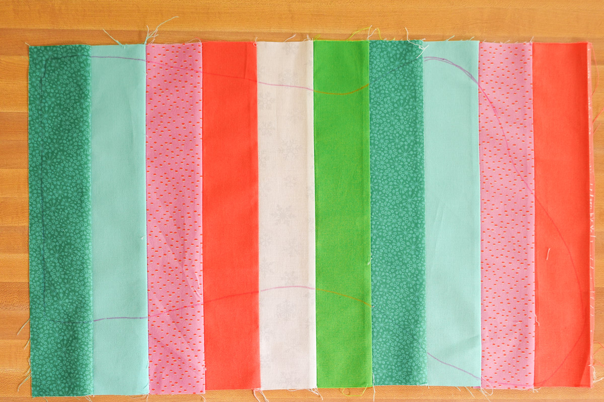 Blue, red, pink, and green striped fabric piece with stocking template marked