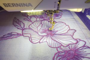 Close up view of purple flowers machine embroidered on organza