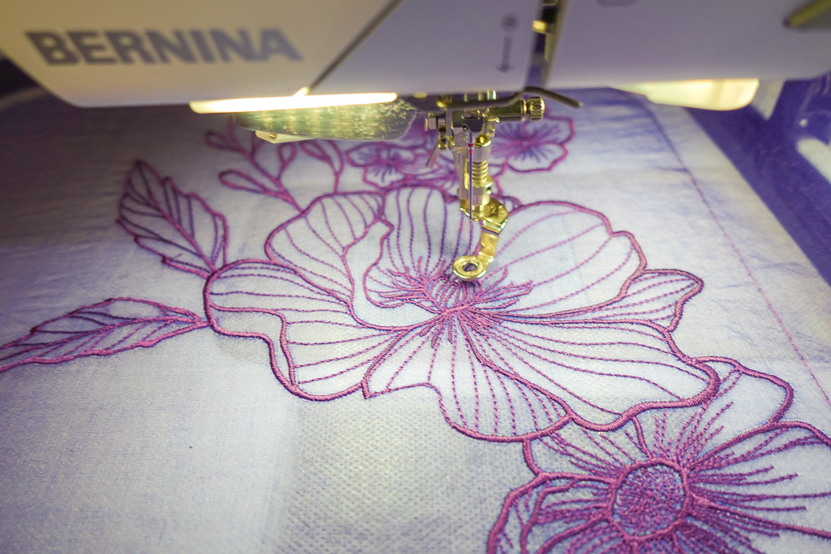 Close up view of purple flowers machine embroidered on organza