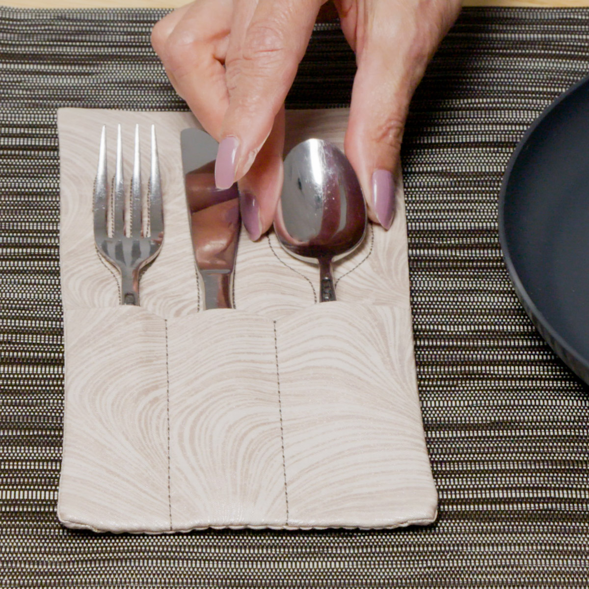 placing a spoon into the cream swirl silverware holder