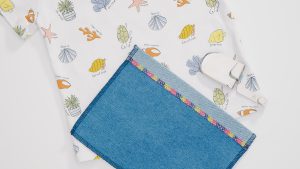 blue fabric and sea-themed white fabric on a white background, featring a variety of colorful threads