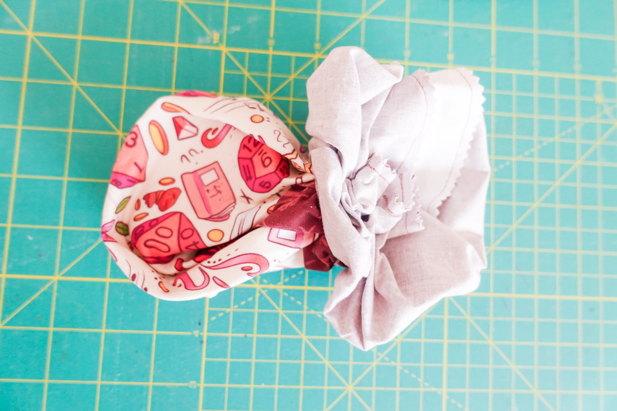 fabric being pulled right side out on a green cutting mat