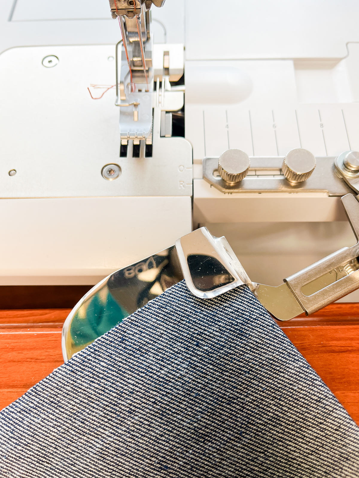 Insert blue fabric into the hemmer attachment