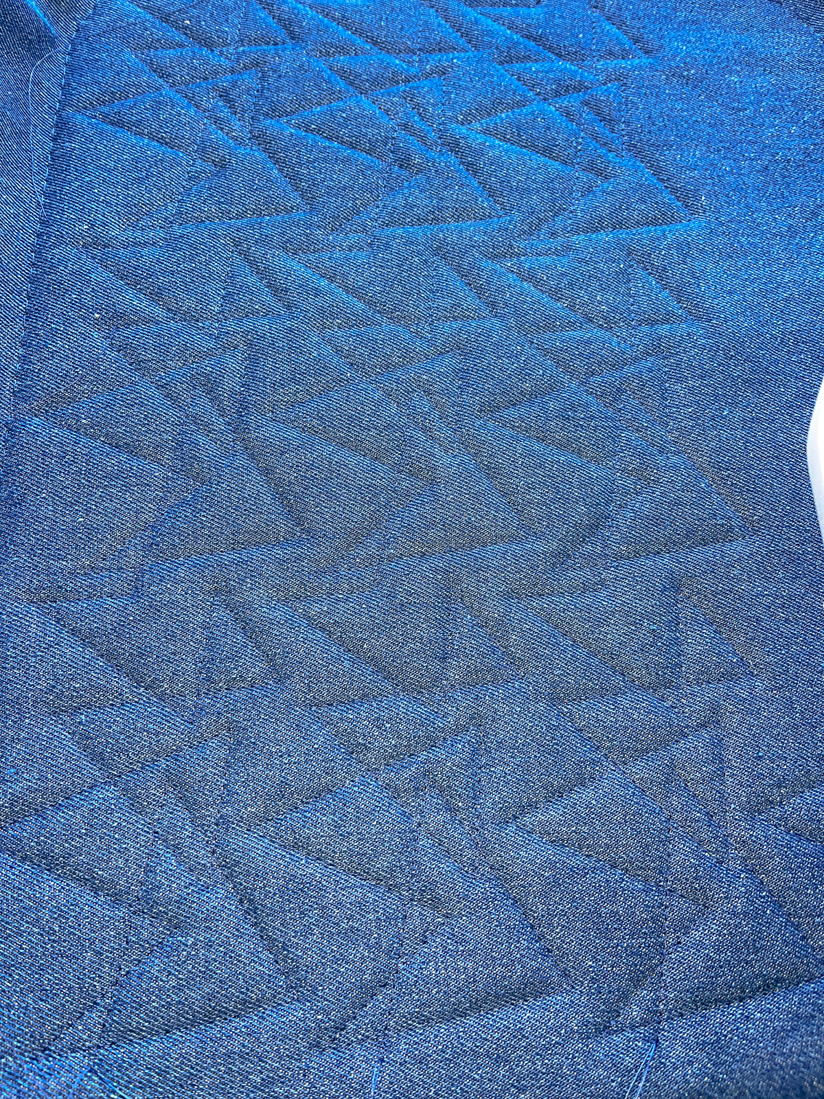 Finished view of quilt design stitched out on blue denim