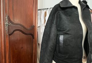 A finished black suede jacket with smooth grain leather collar and welt pockets.