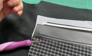 A seam ripper is used to pull threads to the back of the project to tie off and secure stitching rather than backstitching.