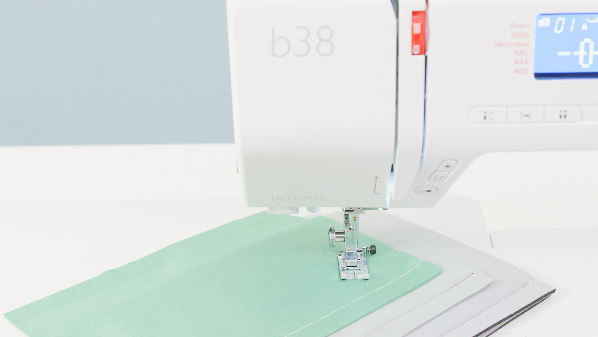 b38 sewing machine with green and white stretchy fabric underneath the foot