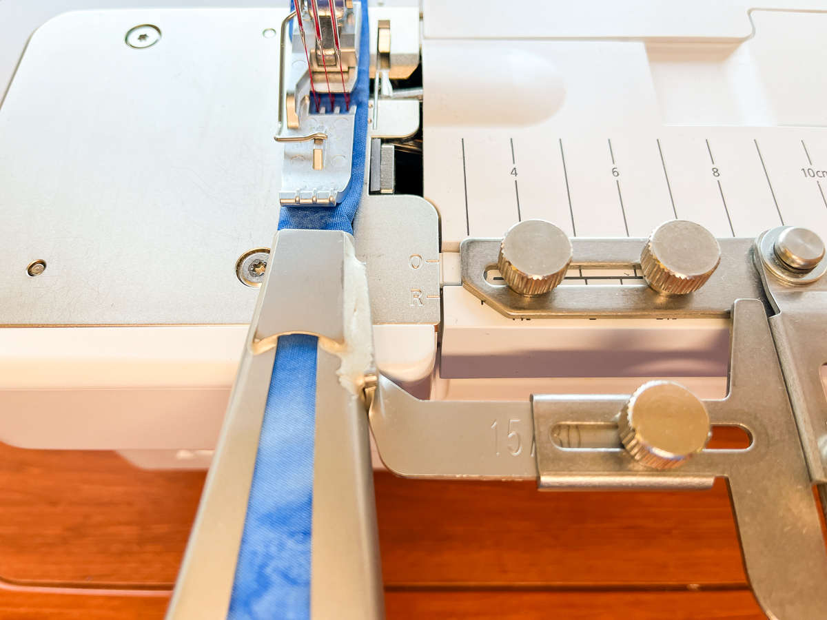 Feeding blue fabric through belt loop folder