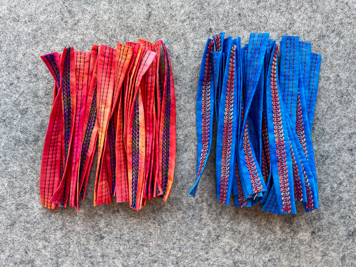 piles of sewn batik fabric strips in blue and orange